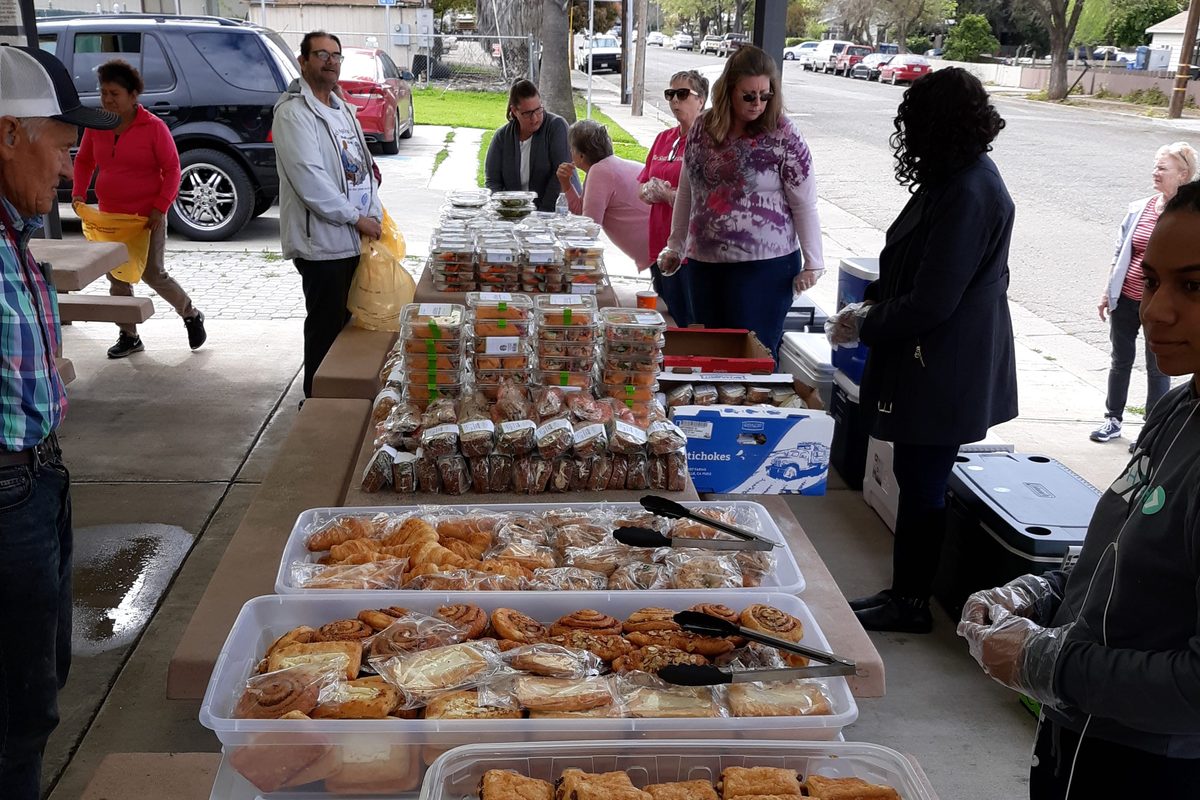 Volunteers serving baked goods at a Bread of Life community food distribution